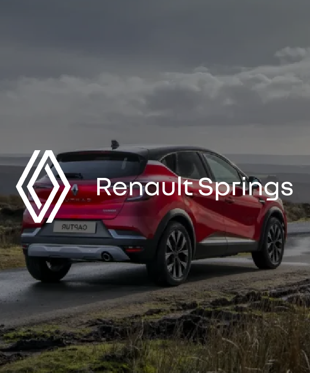 Red Renault SUV on a coastal road with Renault logo and the text 'Renault Springs' overlaid.
