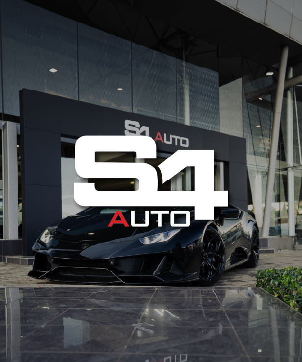 Black sports car on display outside a modern showroom with the S4 Auto logo overlaying the image